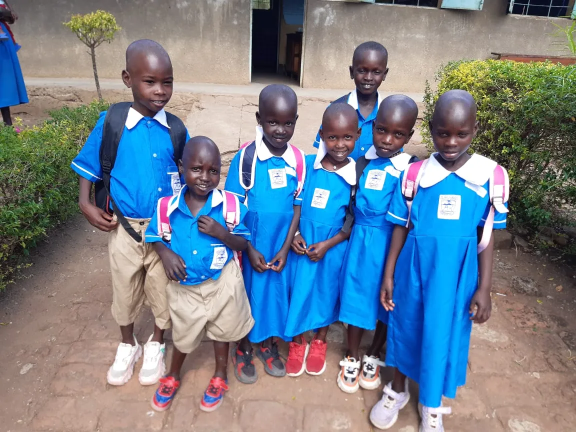 Kinderen in schooluniform bij hun school